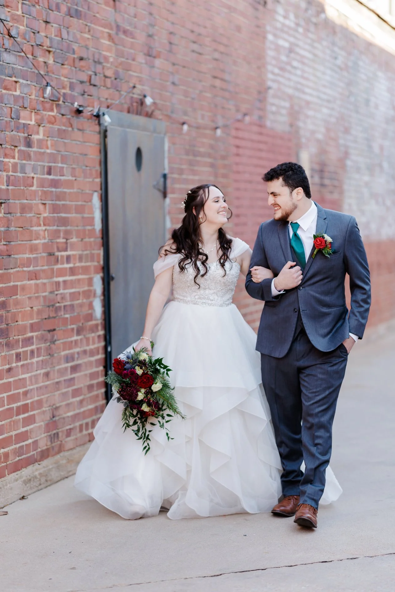 Bride and groom laughing and walking outdoors in the courtyard at The Long Room in Plaza Midwood light and airy photographed by Charlotte wedding photographer Michael Parks, ParksPictures film