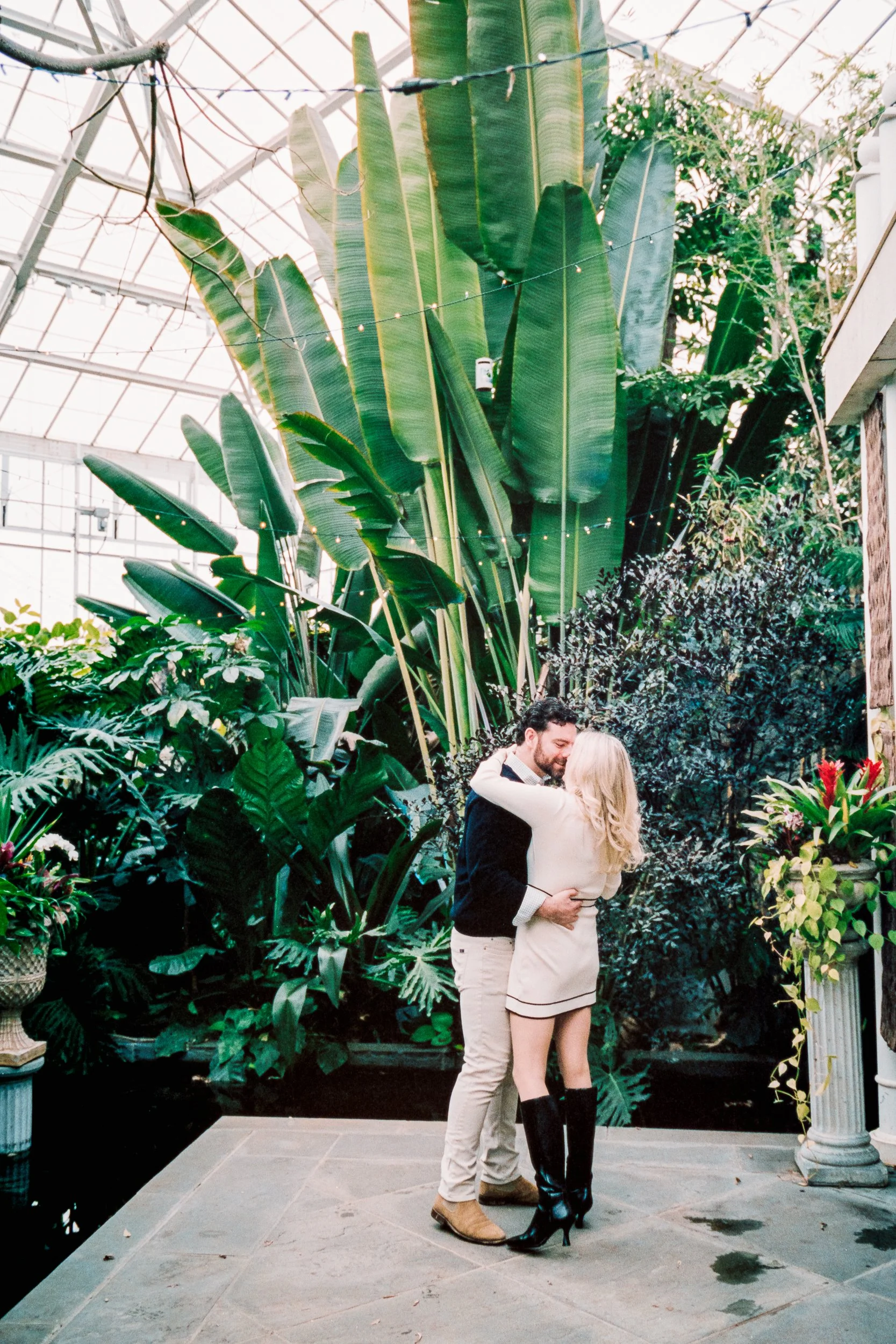 Boyfriend popping the question to his girlfriend in a surprise proposal in Williamson Conservatory Daniel Stowe Conservancy reflecting pond in the background after he proposed, on Kodak Portra 400 film by ParksPictures