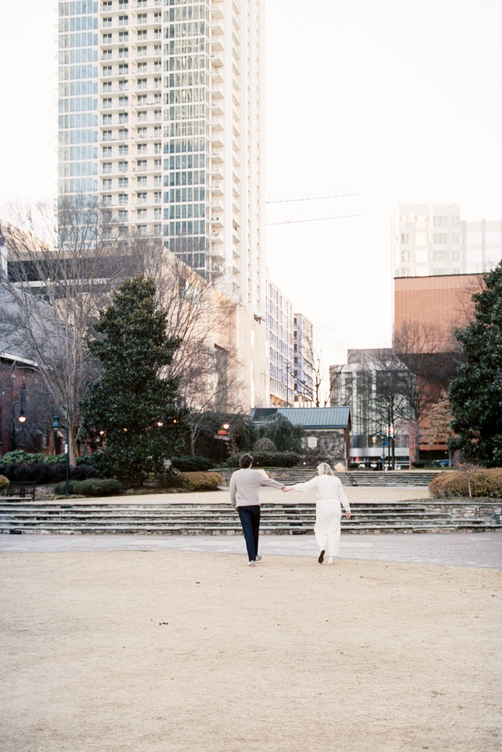 Engaged couple on 35mm Portra 400 film on The Green by St. Peter Catholic Church in Uptown Charlotte NC