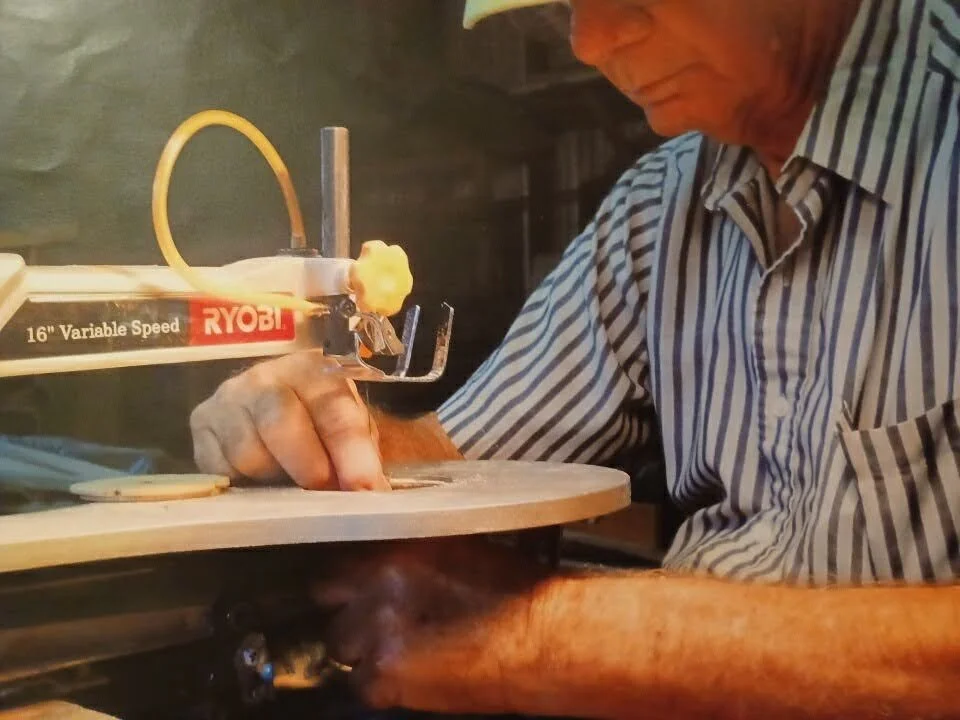 Changing the blade on one of his scroll saws.