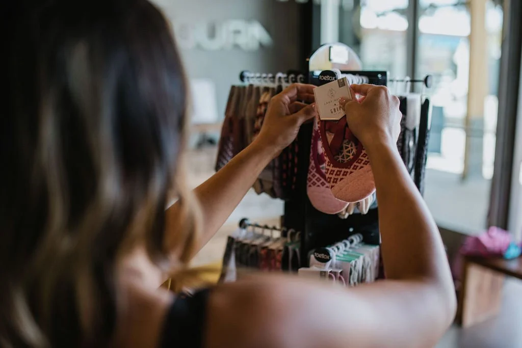 Mountain landscape with snow-capped peaks and a small modern building on grassy hills under an overcast sky.