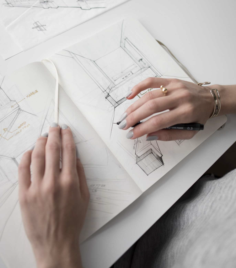 Hands reviewing architectural sketches and floor plans on paper.