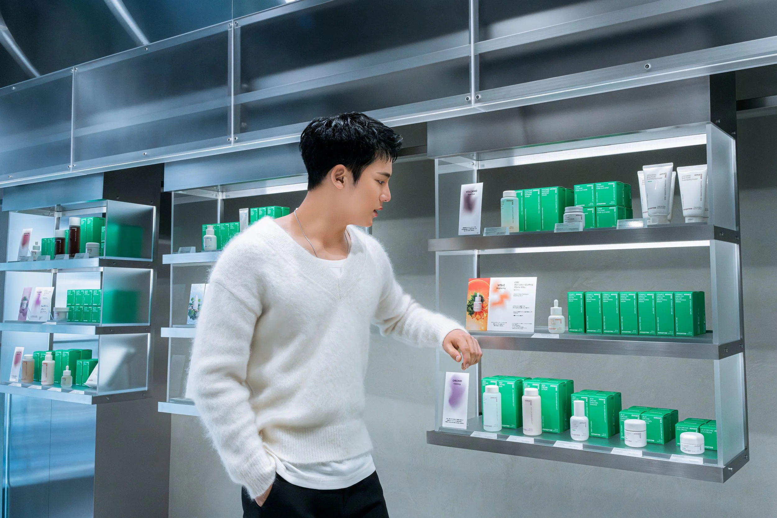A person shopping for skincare products on store shelves.