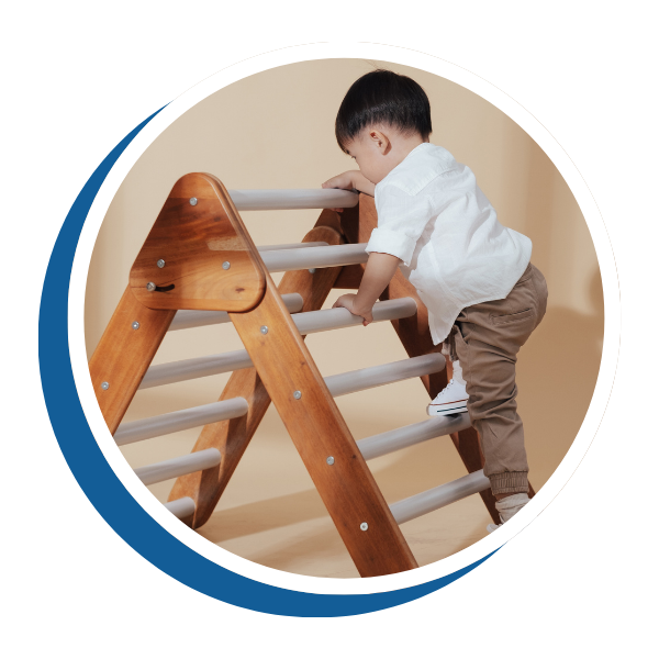 toddler climbing a wooden toy ladder