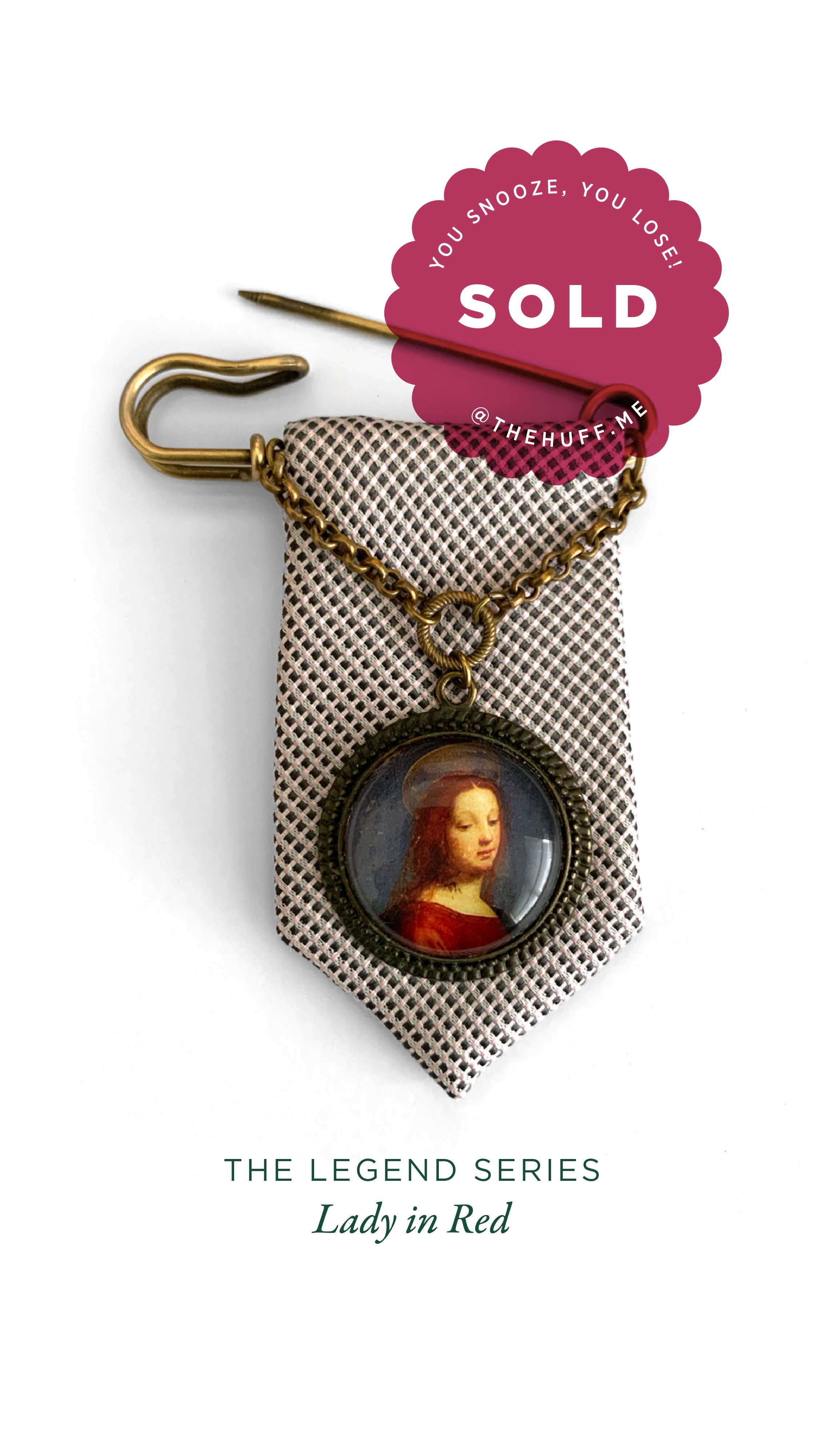A decorative necklace with a pendant featuring a classic portrait of a woman in red, resting on a patterned fabric background, with a sold sticker overlay.