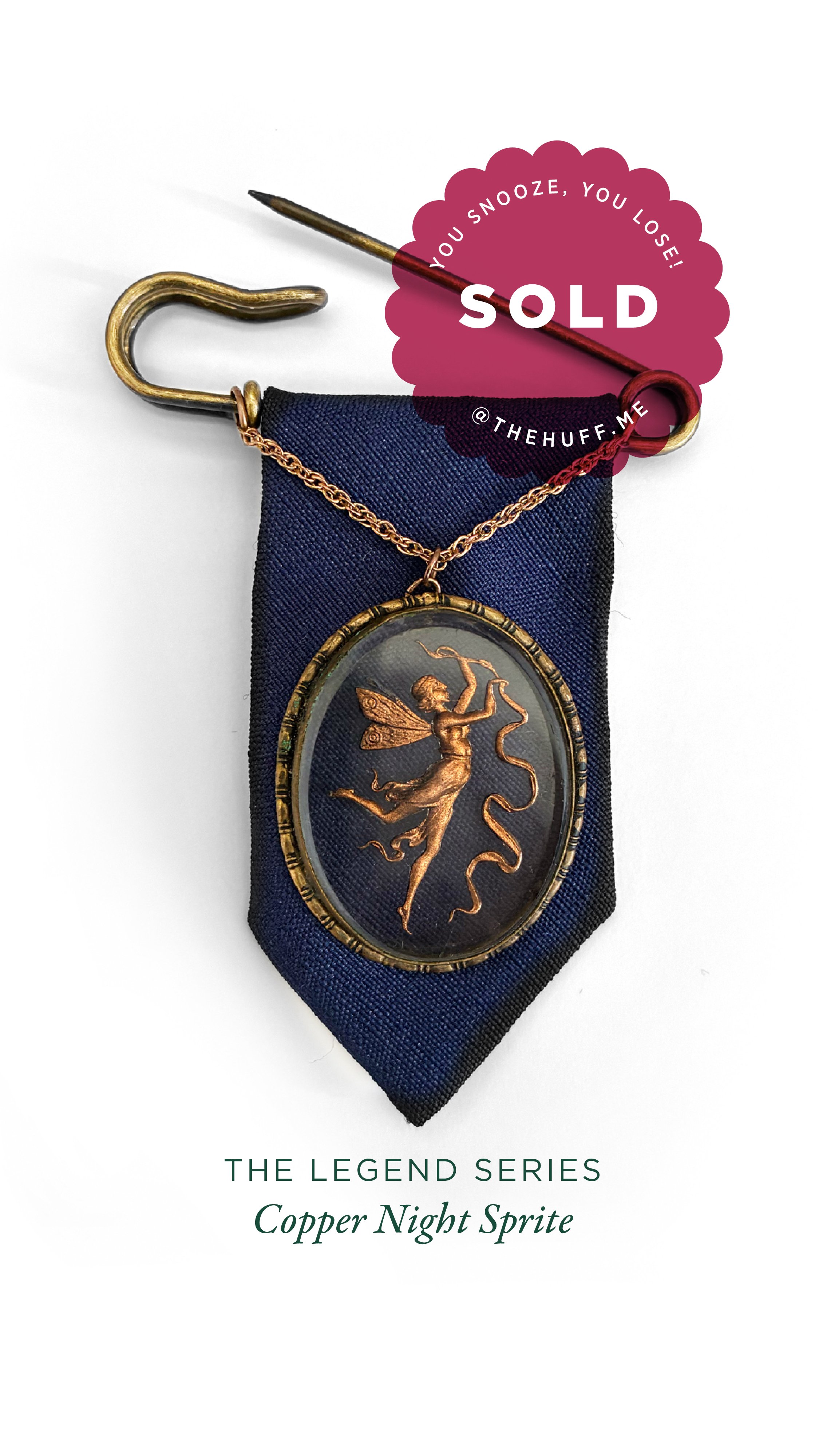 A vintage-style pendant necklace with a fairy image, displayed on a dark blue ribbon, with a gold safety pin, and a 'SOLD' sticker from @thehuff.me.