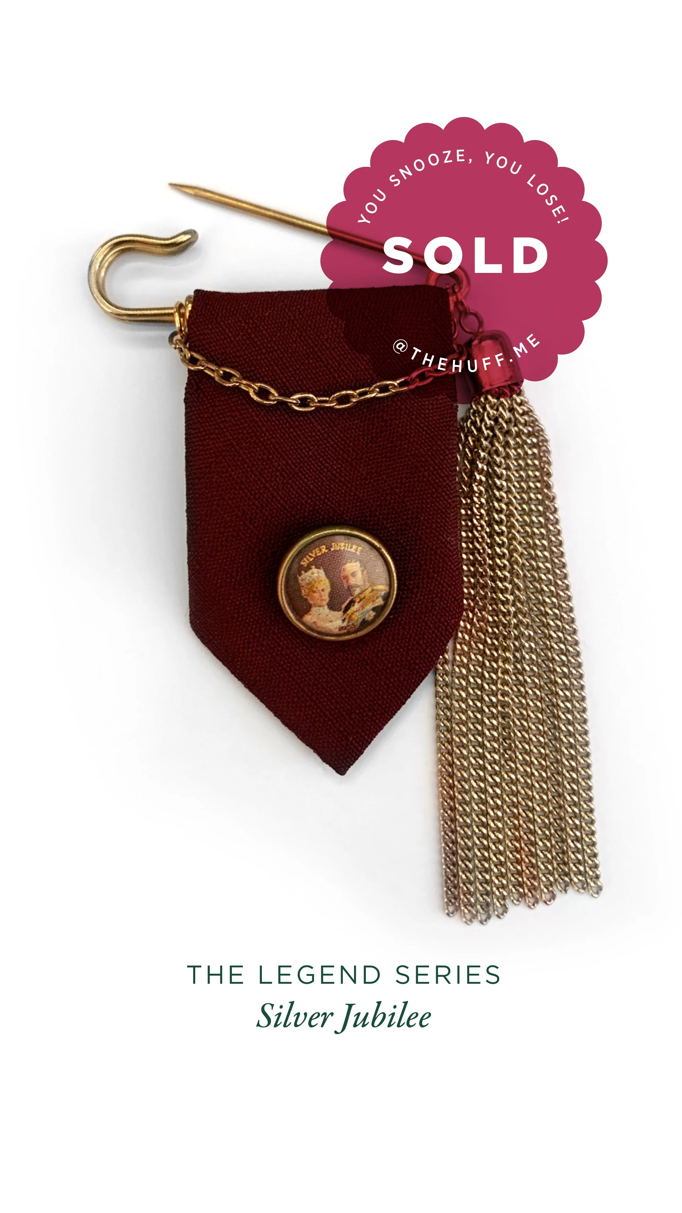 A jewellery piece from 'The Legend Series Silver Jubilee' collection featuring a burgundy fabric tie with a vintage badge, gold chain, and a large gold chain tassel. A pink 'Sold' sticker with the text 'You snooze, you lose!' overlays the top right.