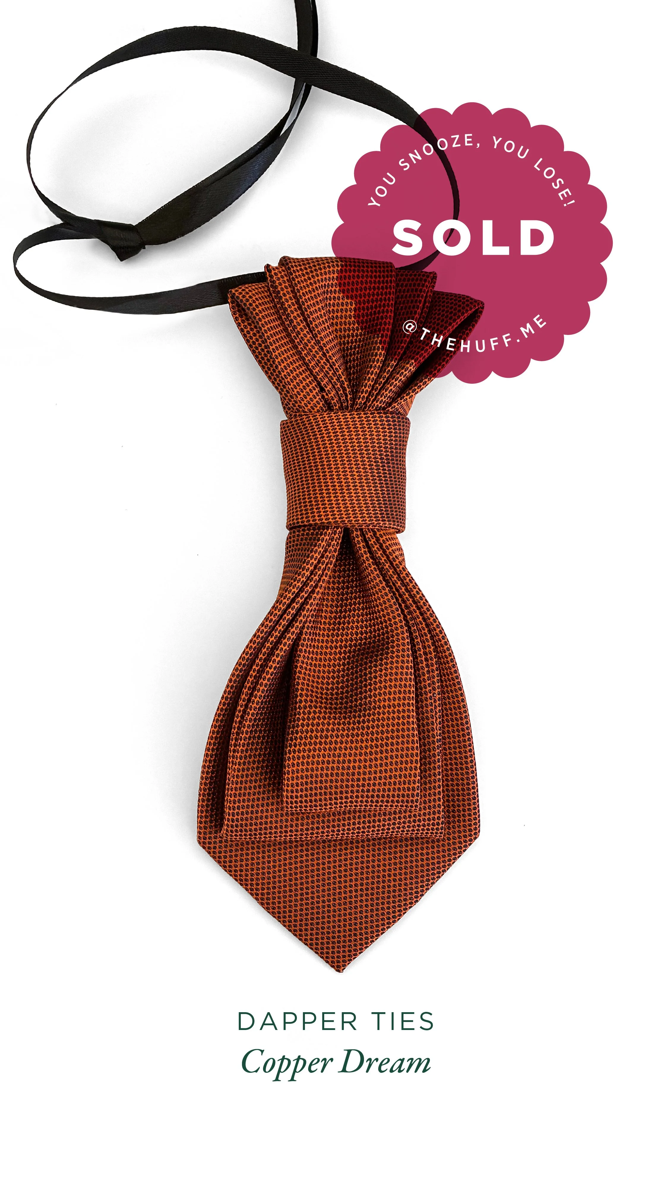 A patterned copper-coloured dapper tie with text indicating it is sold, displayed on a white background.