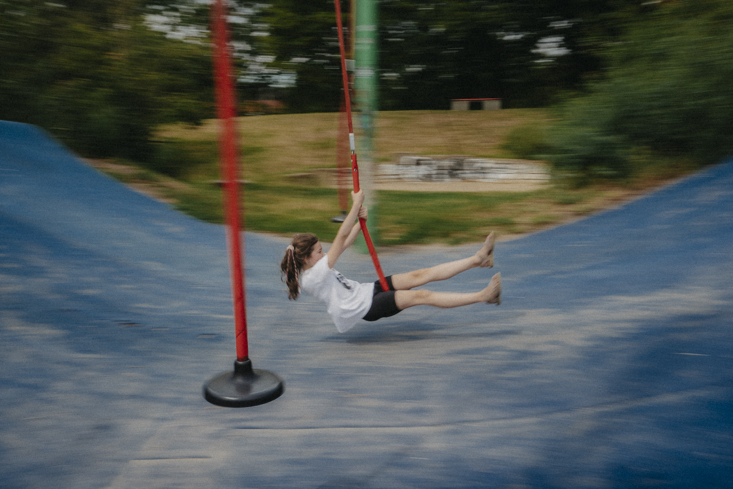 Kind schaukelt schnell auf dem Spielplatz während einer dokumentarischen Familienreportage in Hannover.