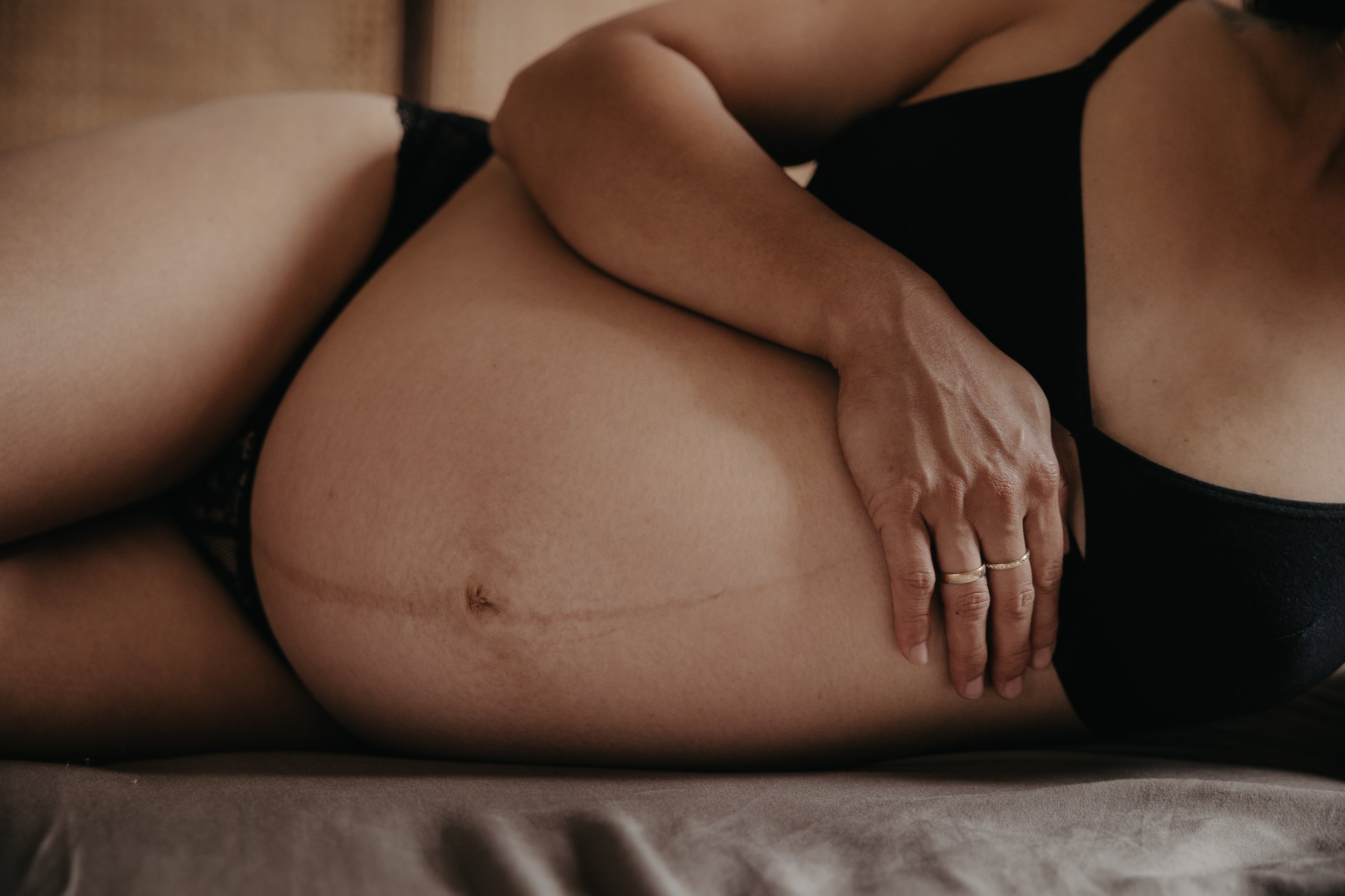 Schwangere Frau bei einem Schwangerschaftsshooting in Hannover. Detailaufnahme vom Babybauch.