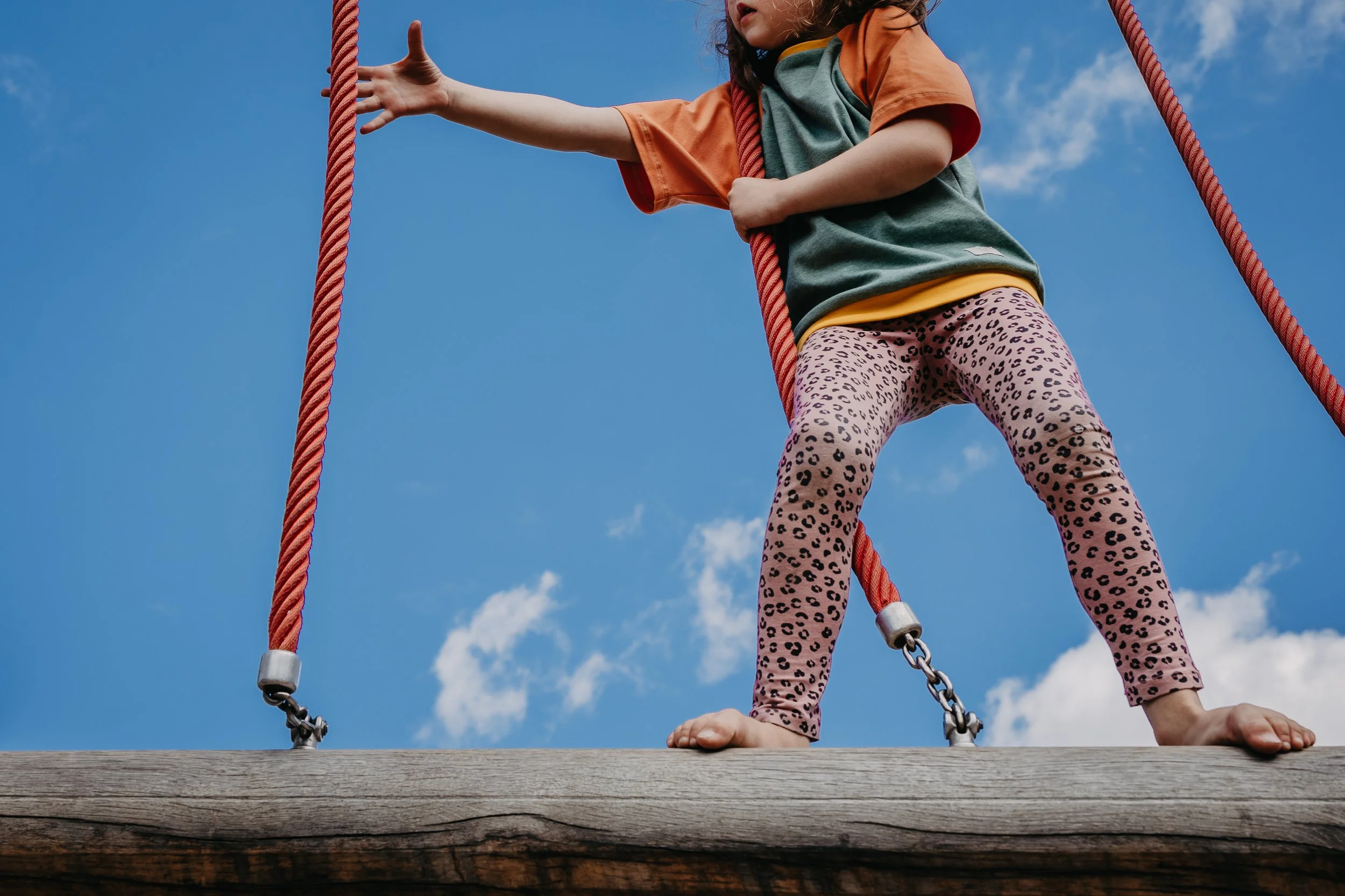 Kind im Oktopulli Balanciert auf dem Spielplatz