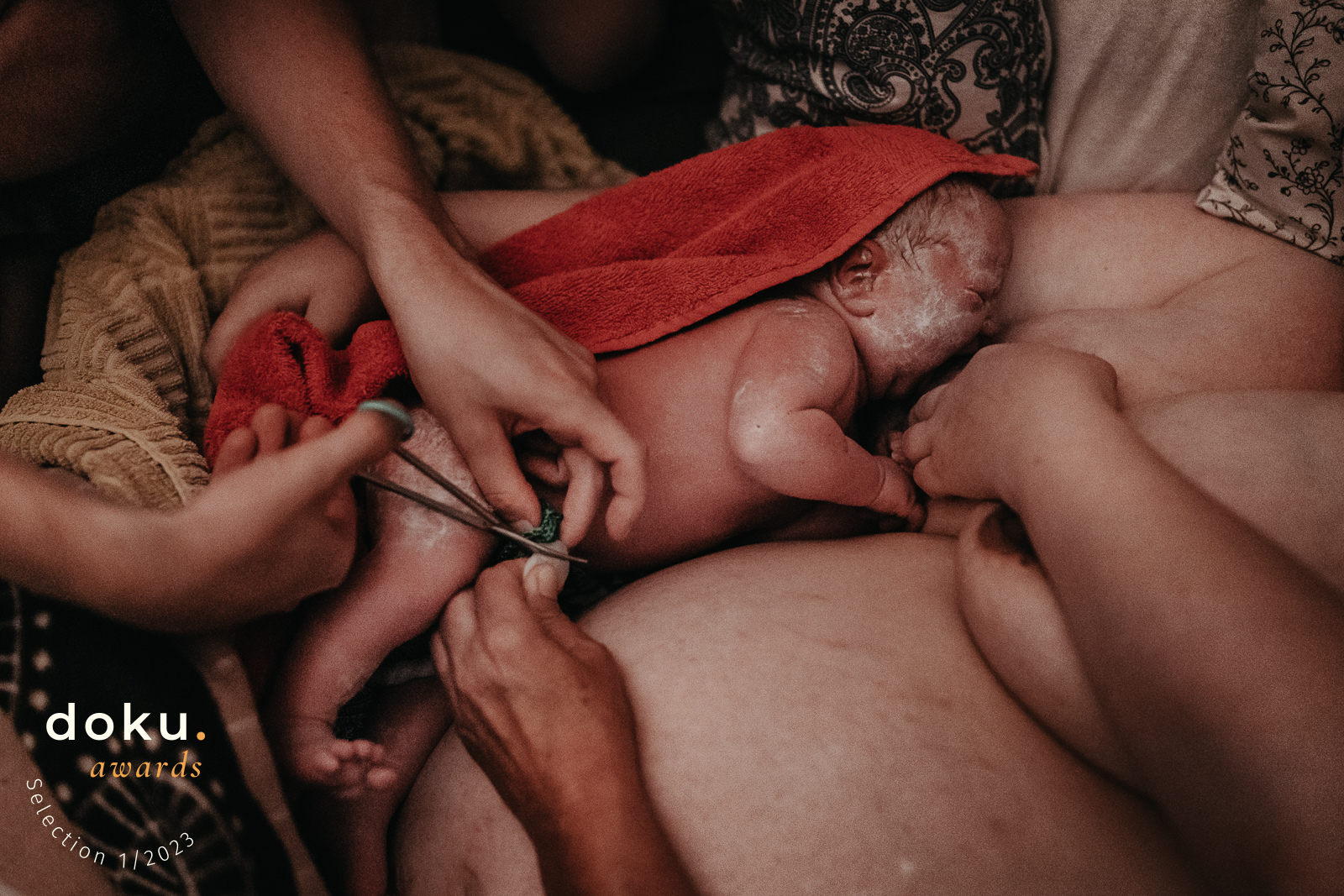 Geburtsfotografin in Hannover fotografiert Neugeborenes auf dem Bauch der Mutter beim Nabelschnurdurchtrennen