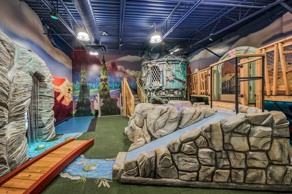 An elaborate, whimsical indoor playroom by Charmed Playhouses featuring an enchanted forest theme.