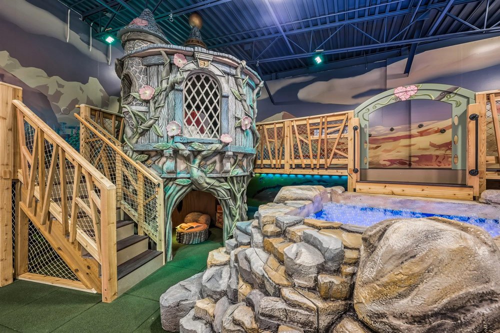An elaborate, whimsical indoor playroom by Charmed Playhouses featuring an enchanted forest theme.