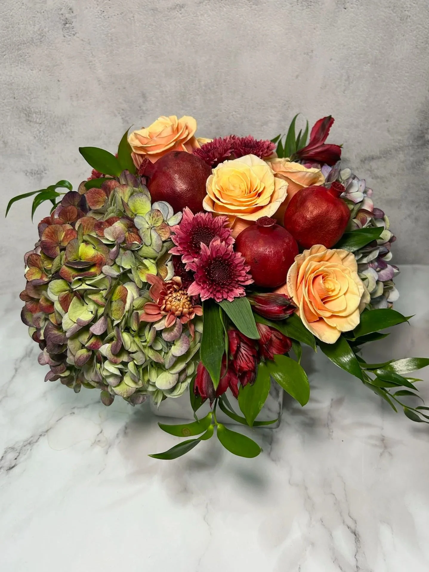 Beautiful fall arrangement adorned with dried pomegranates