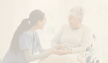 A young healthcare professional and an elderly patient sharing a moment of connection, with the nurse holding the patient's hand and both smiling. Hospice and palliative care can provide comfort when you need it most.