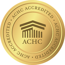 Gold-colored ACHC accreditation badge with a building icon and ACHC text