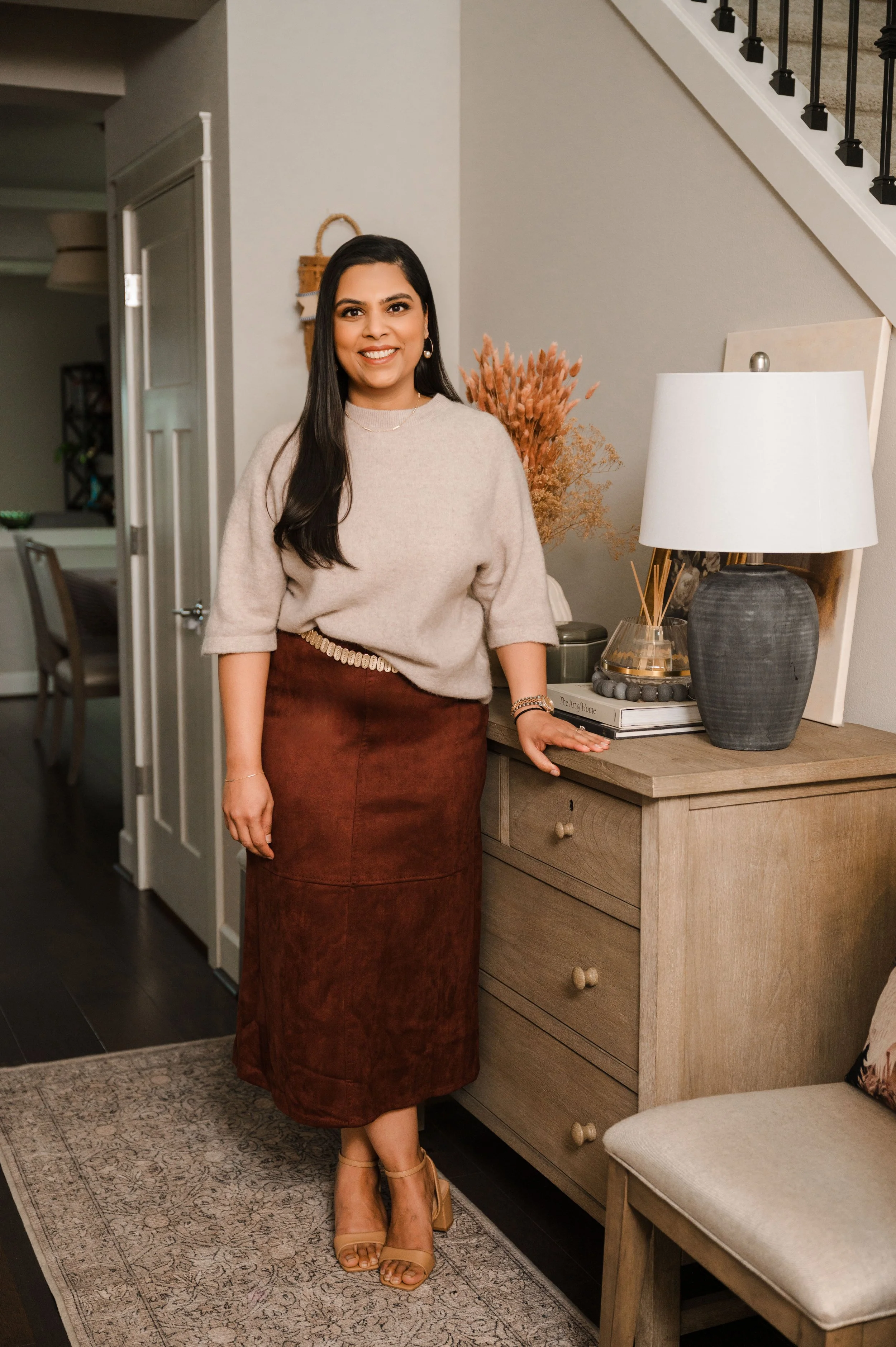 Sunali Agrawal, a Seattle and Eastside interior designer specializing in no-remodel home styling and renter-friendly room transformations, smiling in a modern living space