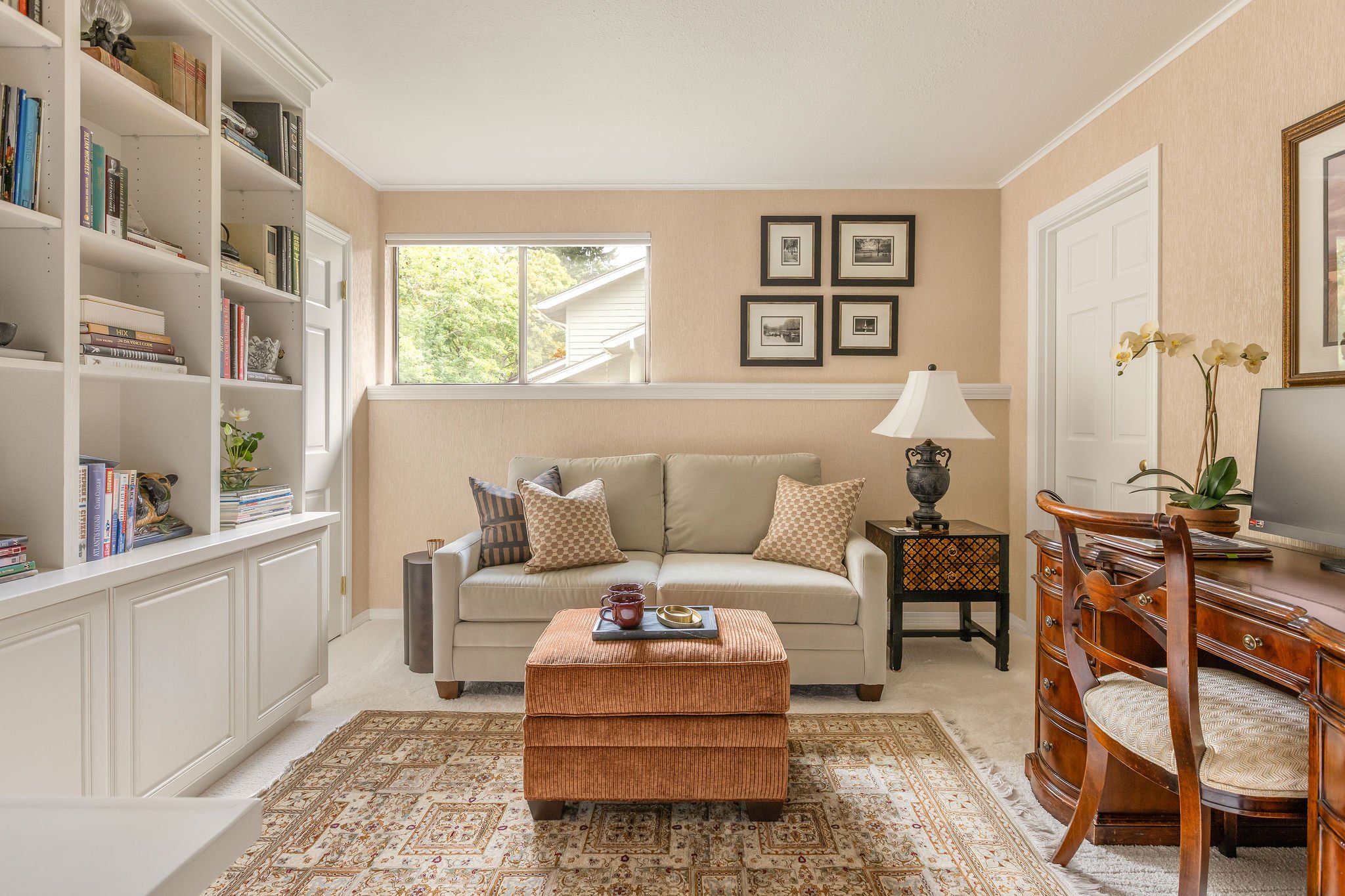 This Redmond home office/lounge was transformed through a thoughtful no‑remodel refresh that blended the client’s favorite existing pieces with curated new additions. The original sofa, meaningful décor, and built‑in bookcase stayed as the foundation