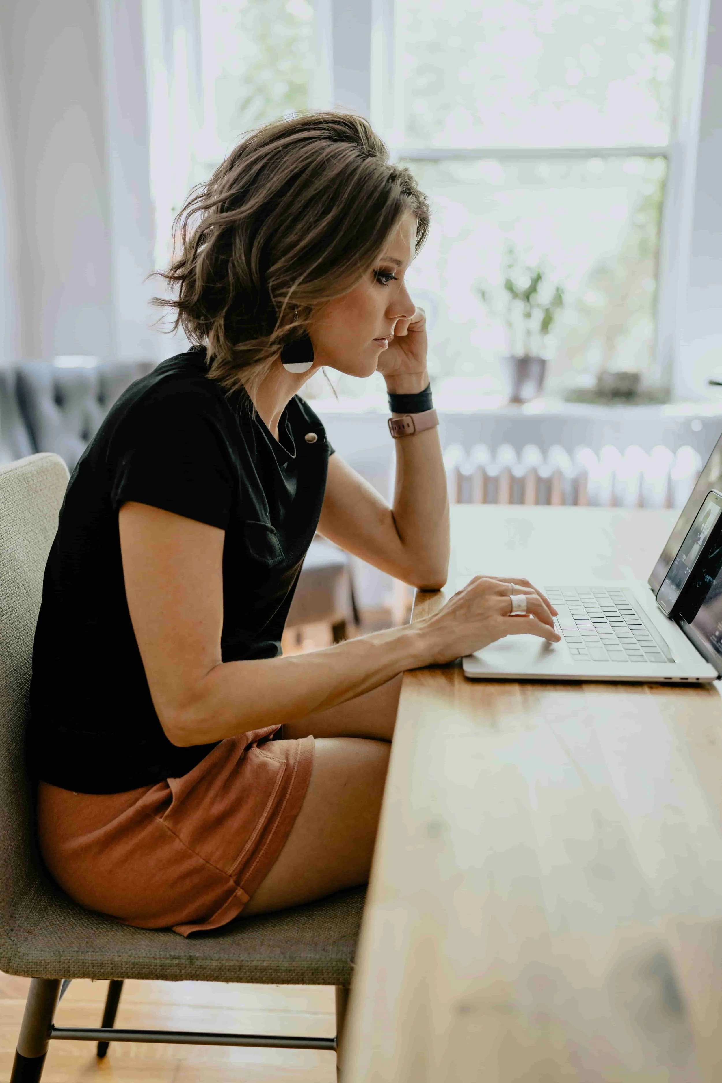 Woman studying French on her laptop at home, preparing for her move to France.