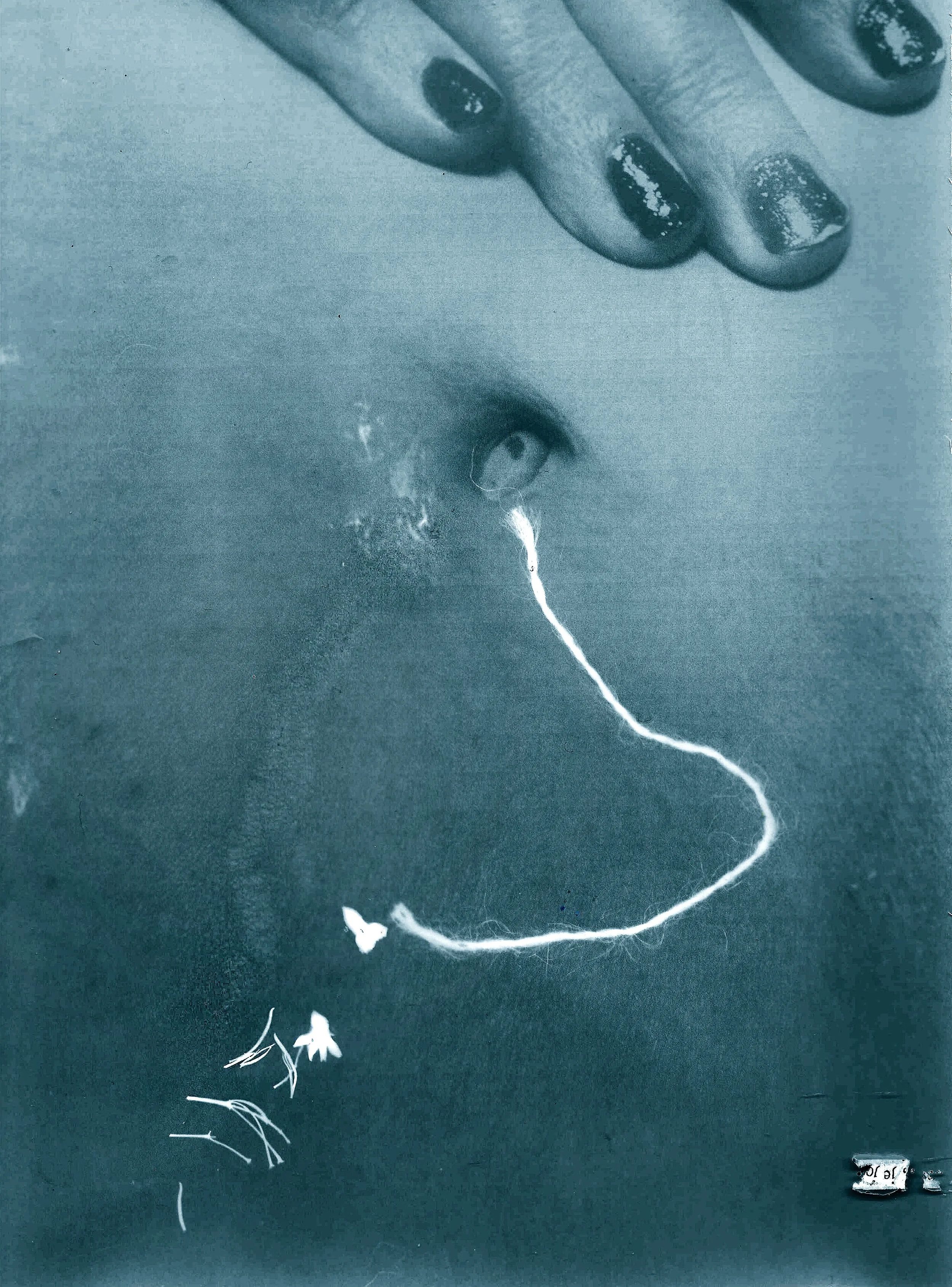 Une main tenant un fil blanc qui forme le contour d'un visage, avec un œil visible près du centre, le tout sur un fond sombre.