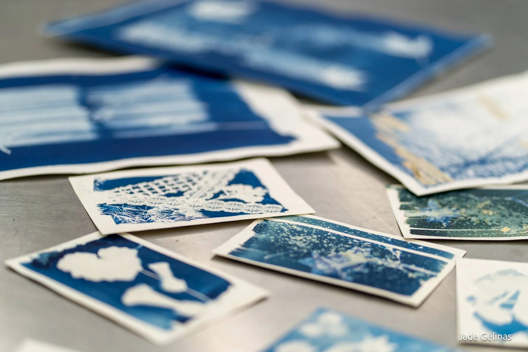 Une collection de photographies artistiques en bleu et blanc, dispersées sur une surface plane.