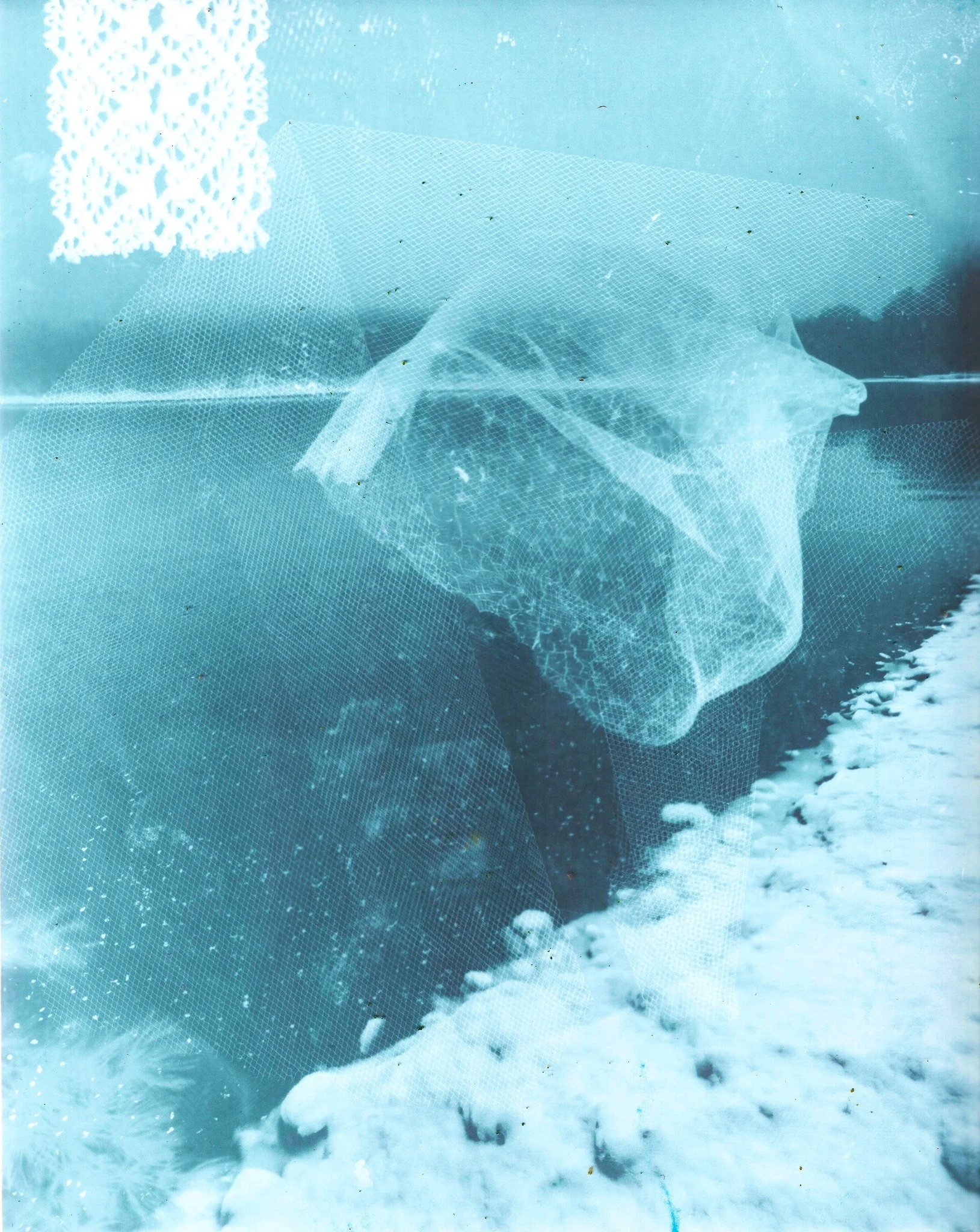 Une personne portant un masque en plastique noir et un vêtement foncé, près de l'eau ou de la neige, avec un filet à la main.