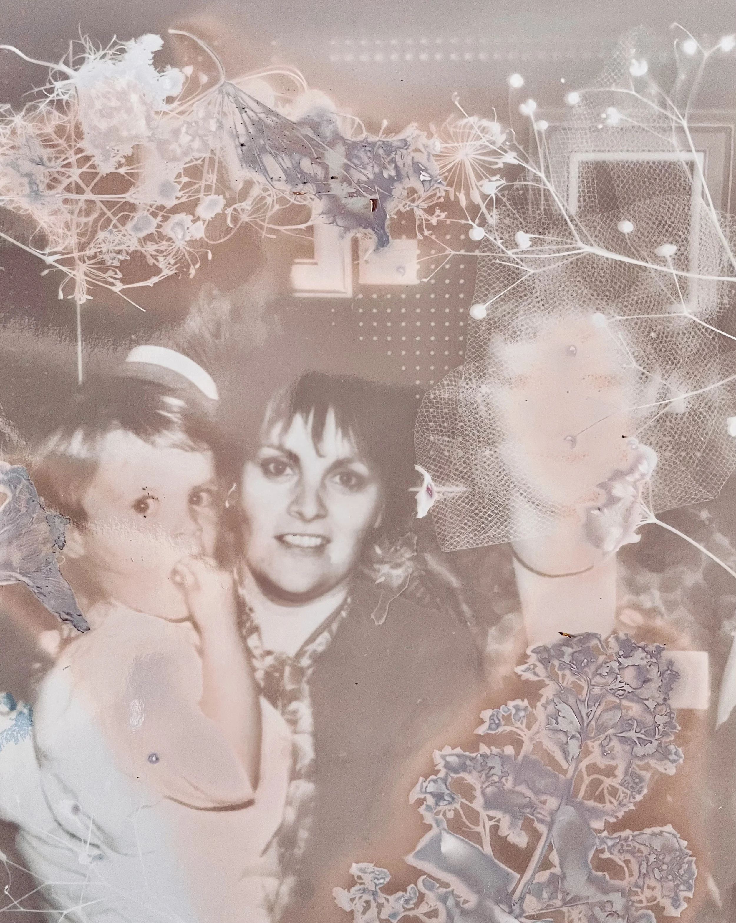 Photo en noir et blanc de trois personnes avec des éléments de décoration florale et de filaments lumineux.