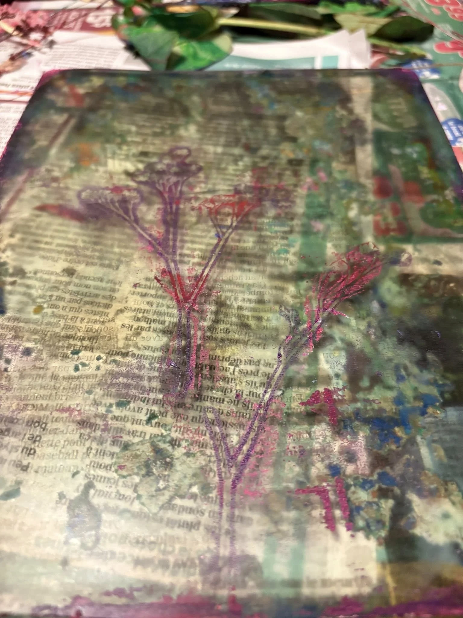 Image d'une planche en bois avec une impression de fleurs de couleurs violette et rose, sur fond de texte en noir.