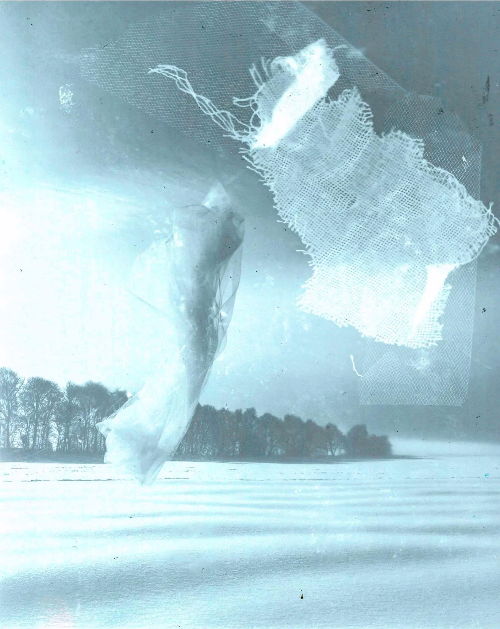 Voiture ou fenêtre avec morceaux de papier ou tissu, avec un paysage enneigé et des arbres en arrière-plan.