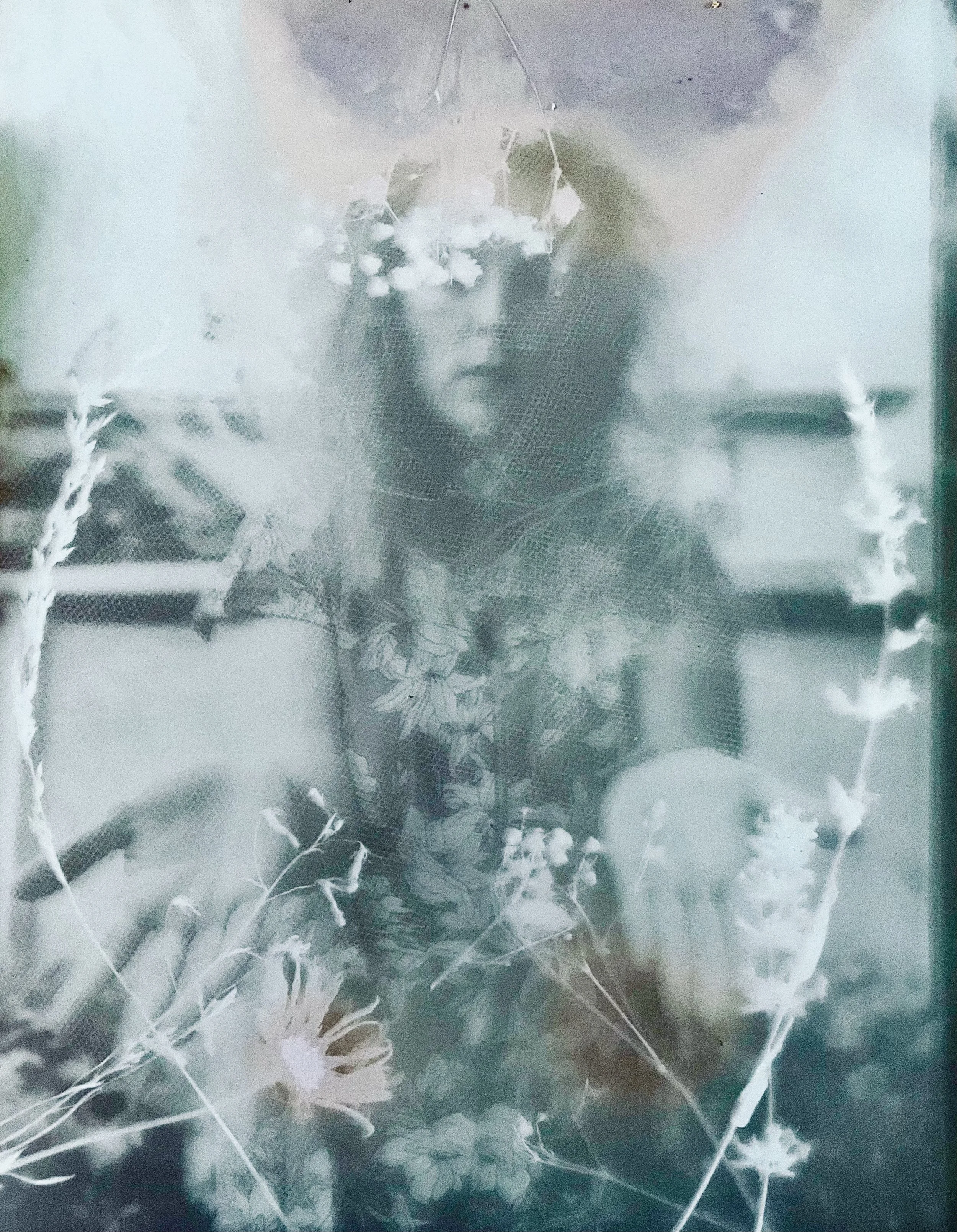 Photo en noir et blanc d'une femme aux cheveux longs portant un chapeau délicatement décoré, avec des plantes en avant-plan