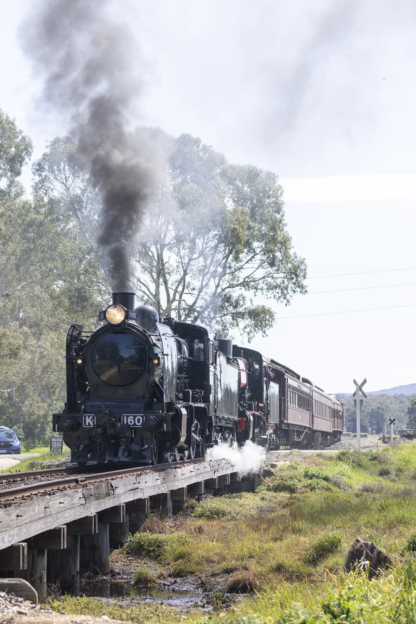 Victorian Goldfields Railway Steam locomotive K 160 and J 549 hauled train crosses the road and small trestle bridge at the up end of Muckleford. Scott Gould A railway Life photography