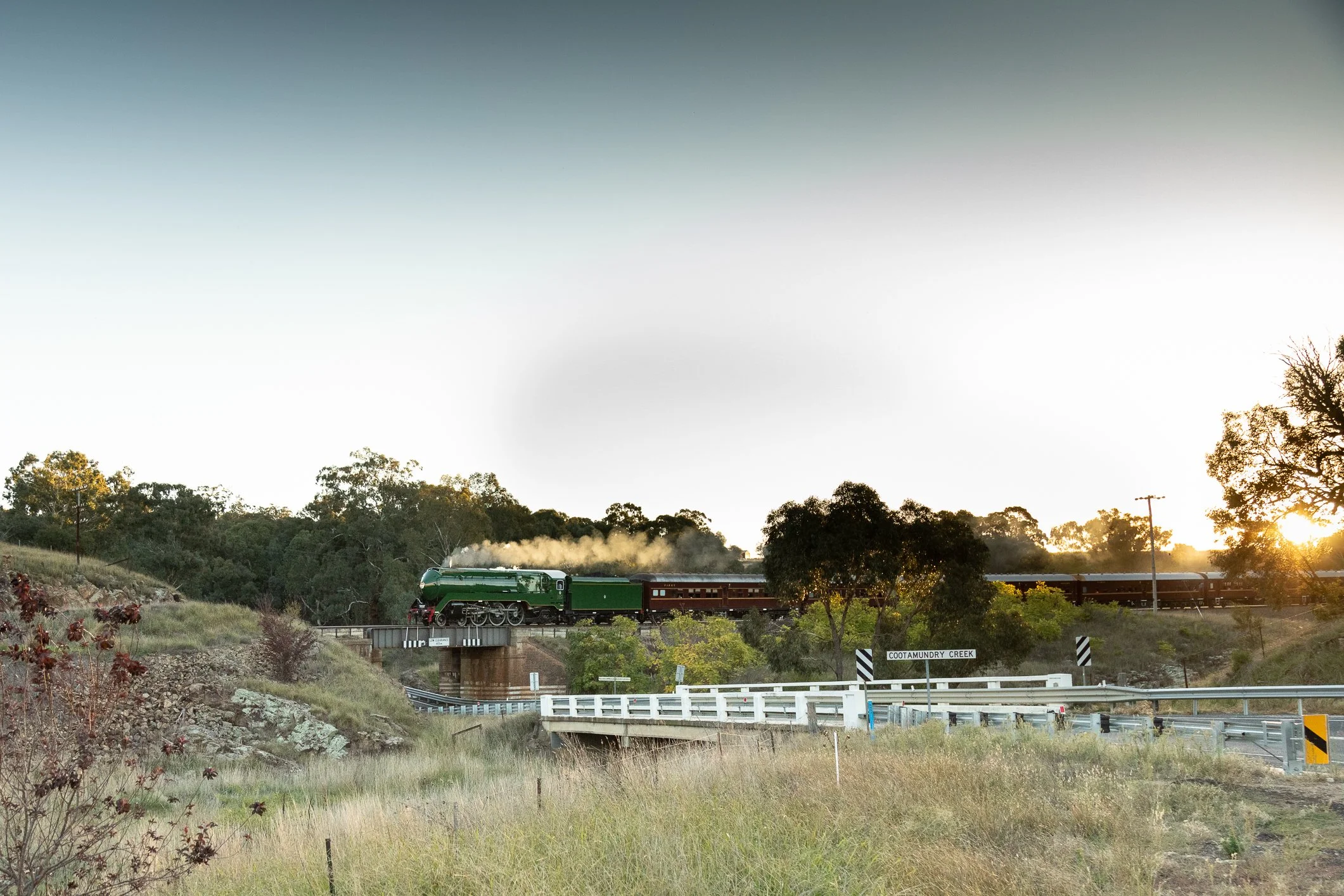the train drifts downhill across the Cootamundry Creek, on the outskirts of Cootamundra. Caught at Cootamundry has some nice soft golden light picking up the streamlined casing of the loco as it leads the cars down the hill Scott Gould A railway life