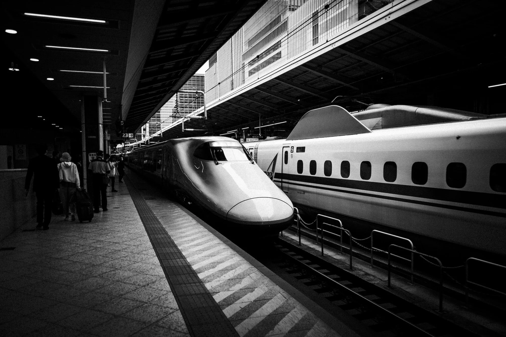 A Railway Life Black and white image of a Shinkansen train at Tokyo station with passengers waiting to board in the few minutes between the train arriving, being cleaned, and seats turned ready for it's next service.