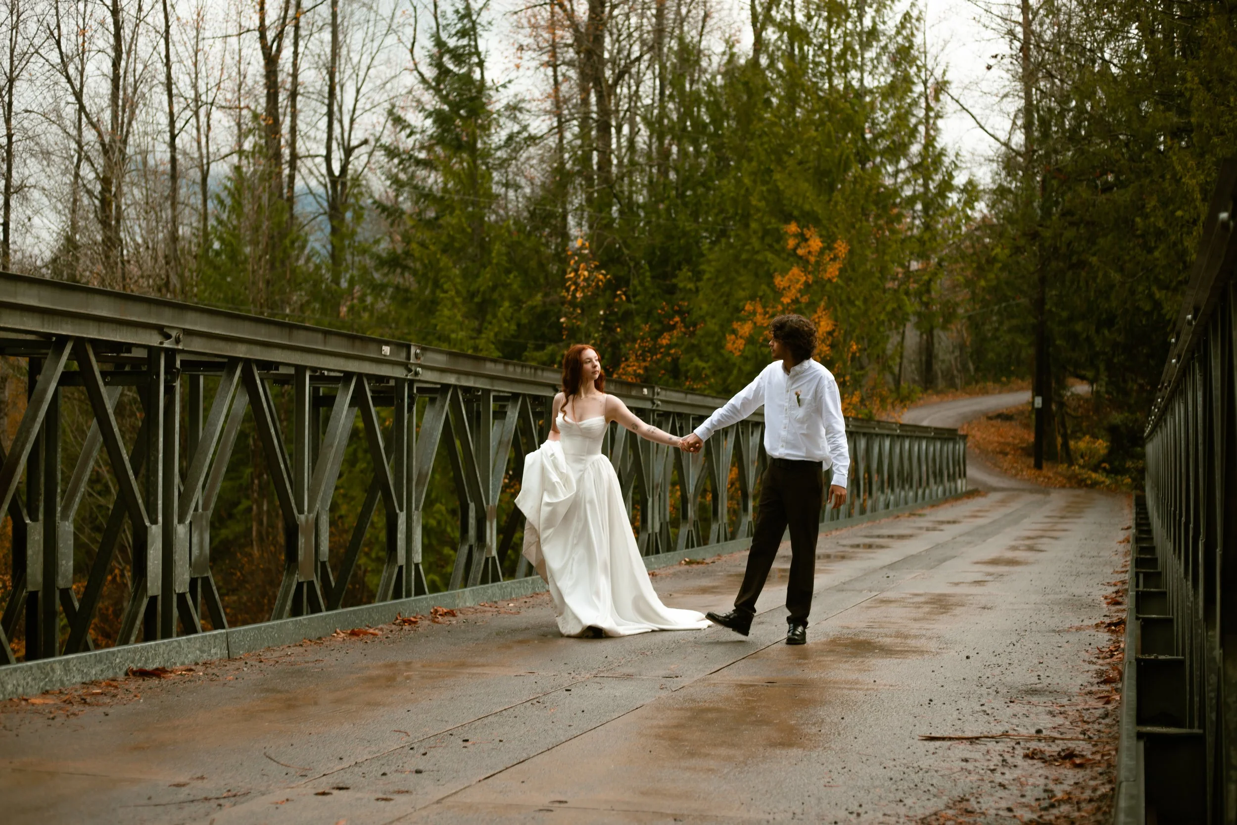 Close-up of a smiling woman with glasses and hoop earrings, indoors with blurred background.