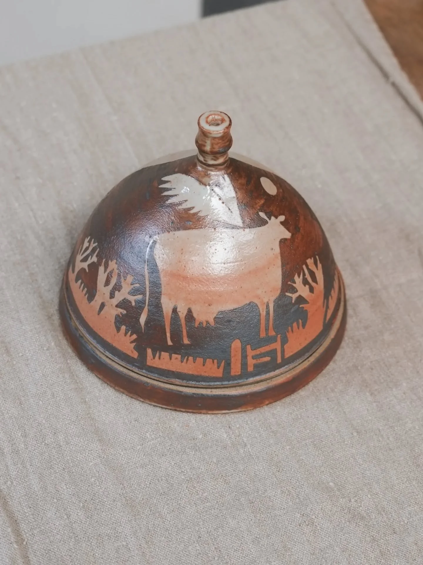 The Flying Cow Butter Dome. Why is the cow flying? Well why not! Maybe she saw juicier, greener grass in a different field. Maybe her legs are tired and she needs a break from standing on them. Maybe her calf escaped and she's gone to find it. 

Than