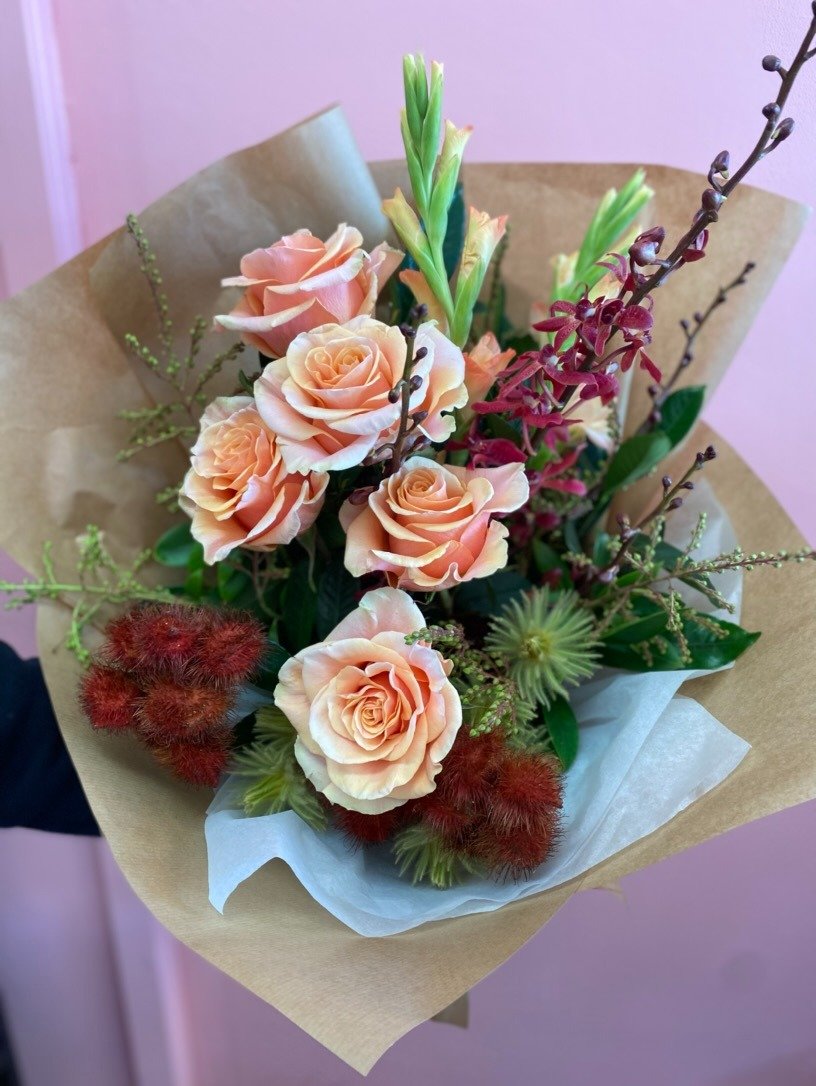 Beautiful seasonal bouquet of roses, gladioli, orchids and native flowers. In orange, red and peach, with lovely wrapping. Flowers for delivery in Brisbane and the Redlands