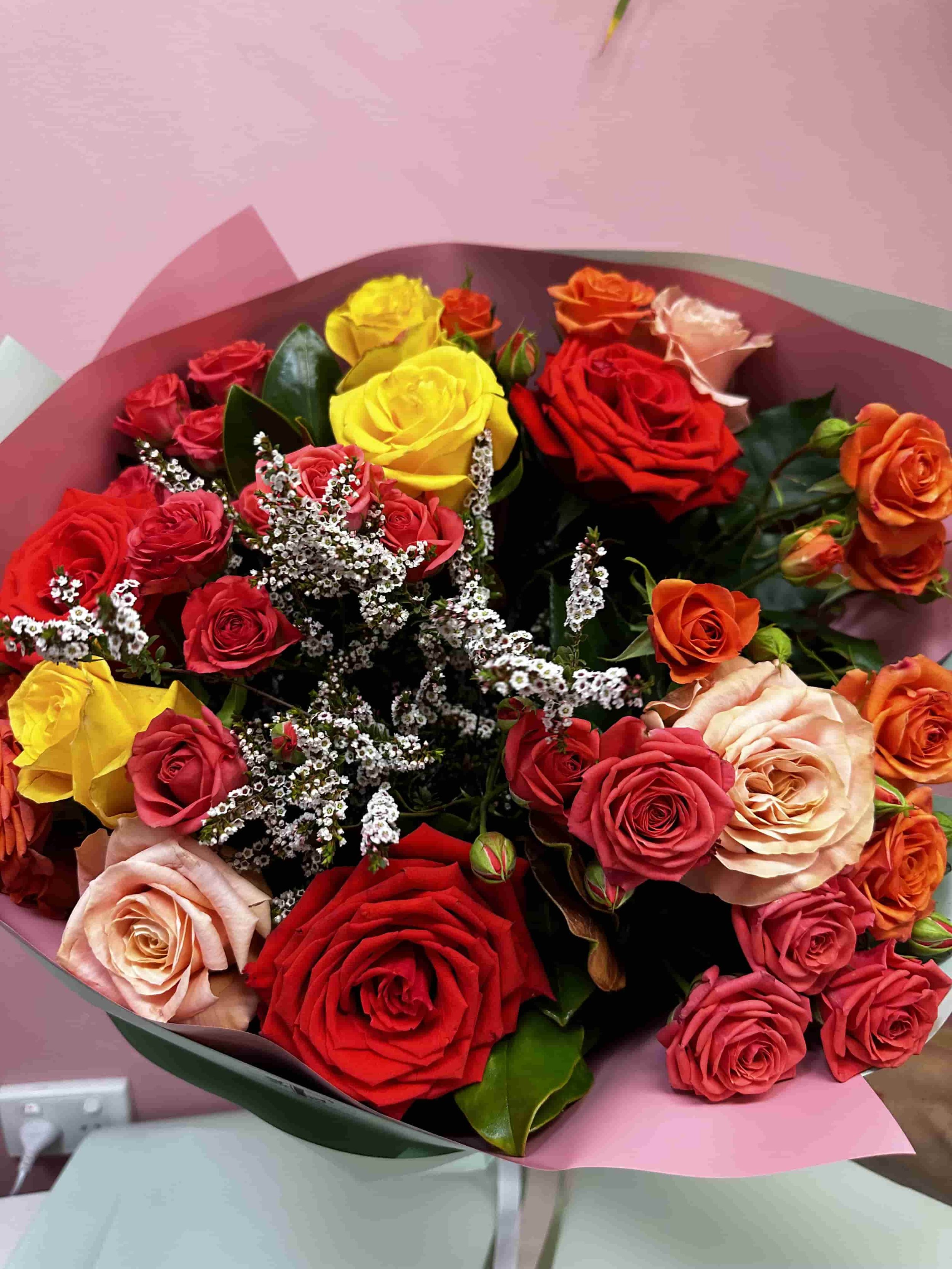 Mixed rose bouquet of locally grown roses, with seasonal foliage and beautiful wrapping. In bright colours.