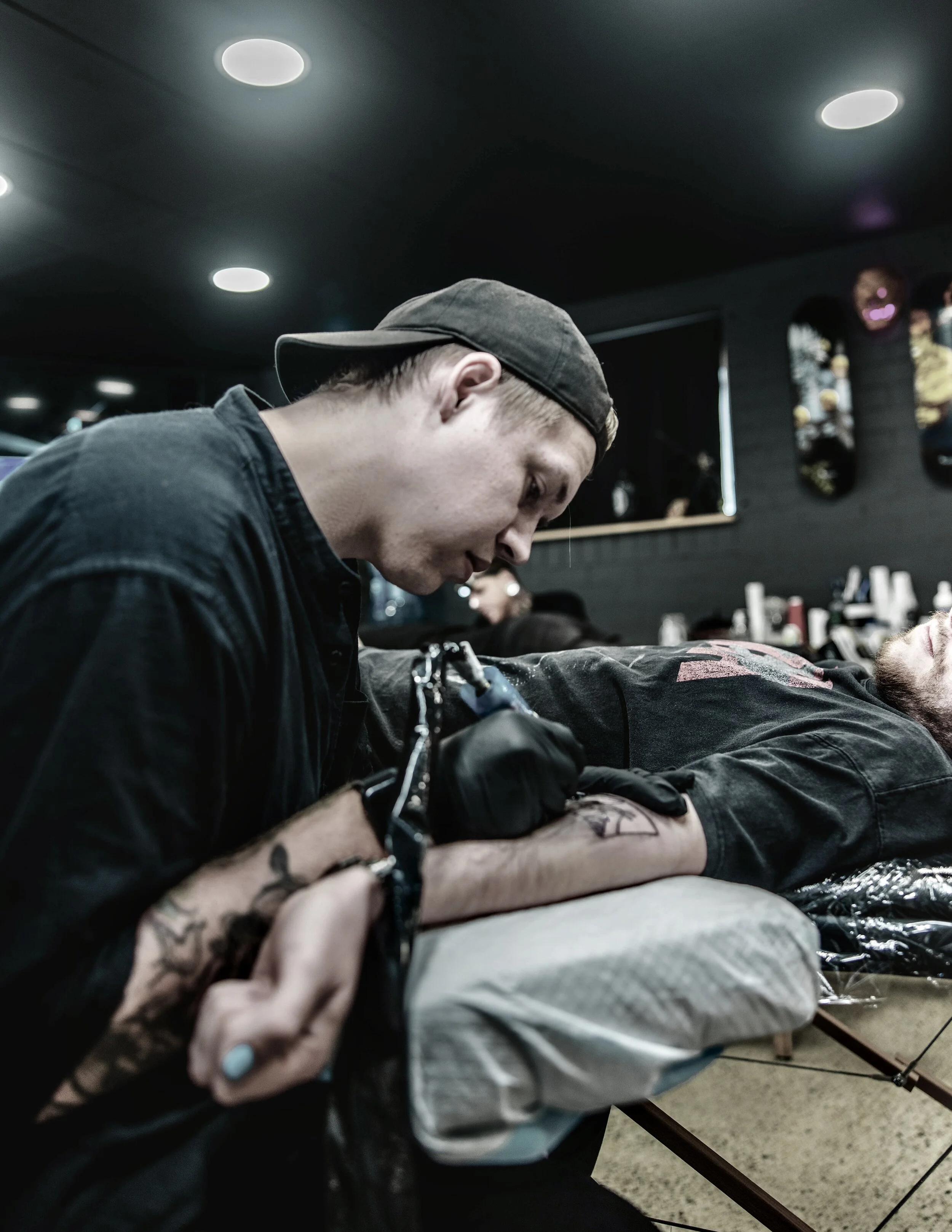 Tobias tattooing an original and custom anime inspired tattoo design on a clients bicep at the tattoo studio Save Point Tattoo in Brisbane.