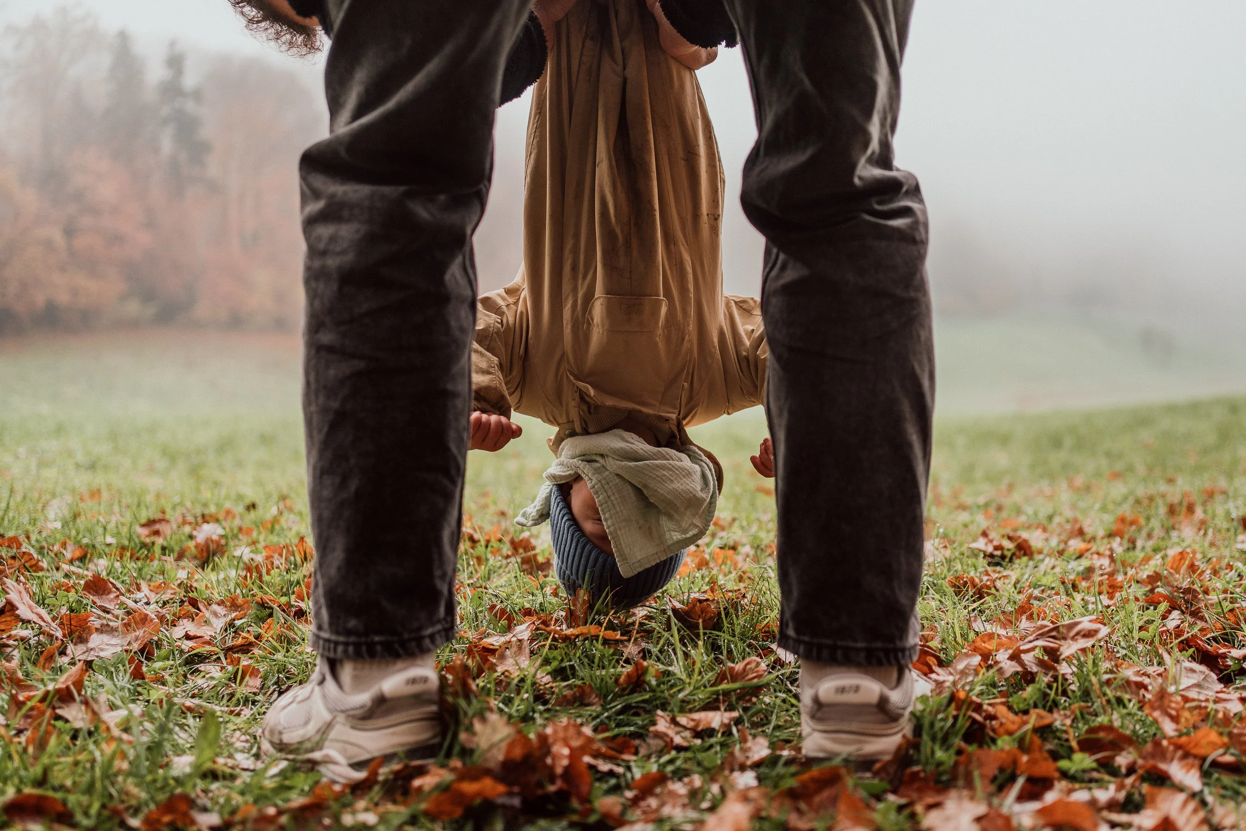 Ein Kind baumelt kopfüber, Papa hält ihn an den Füssen I Familienreportage Luzern