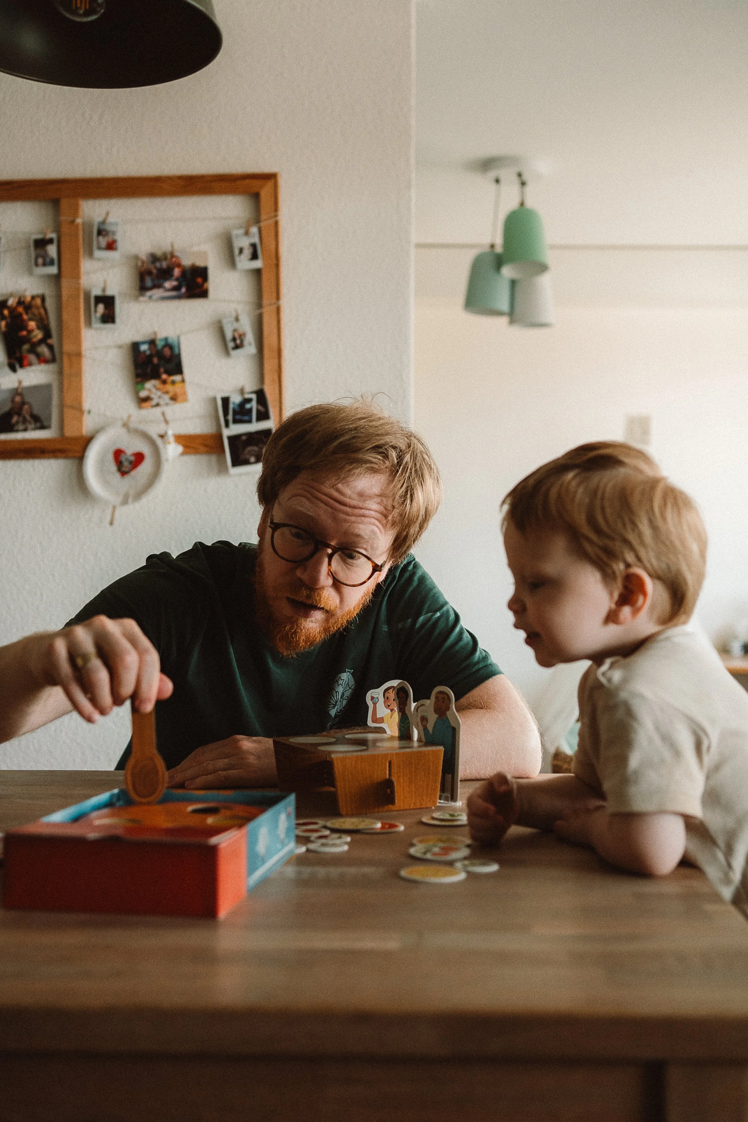Papa spielt mit Sohn Spiele am Tisch I Familienfotografie Luzern