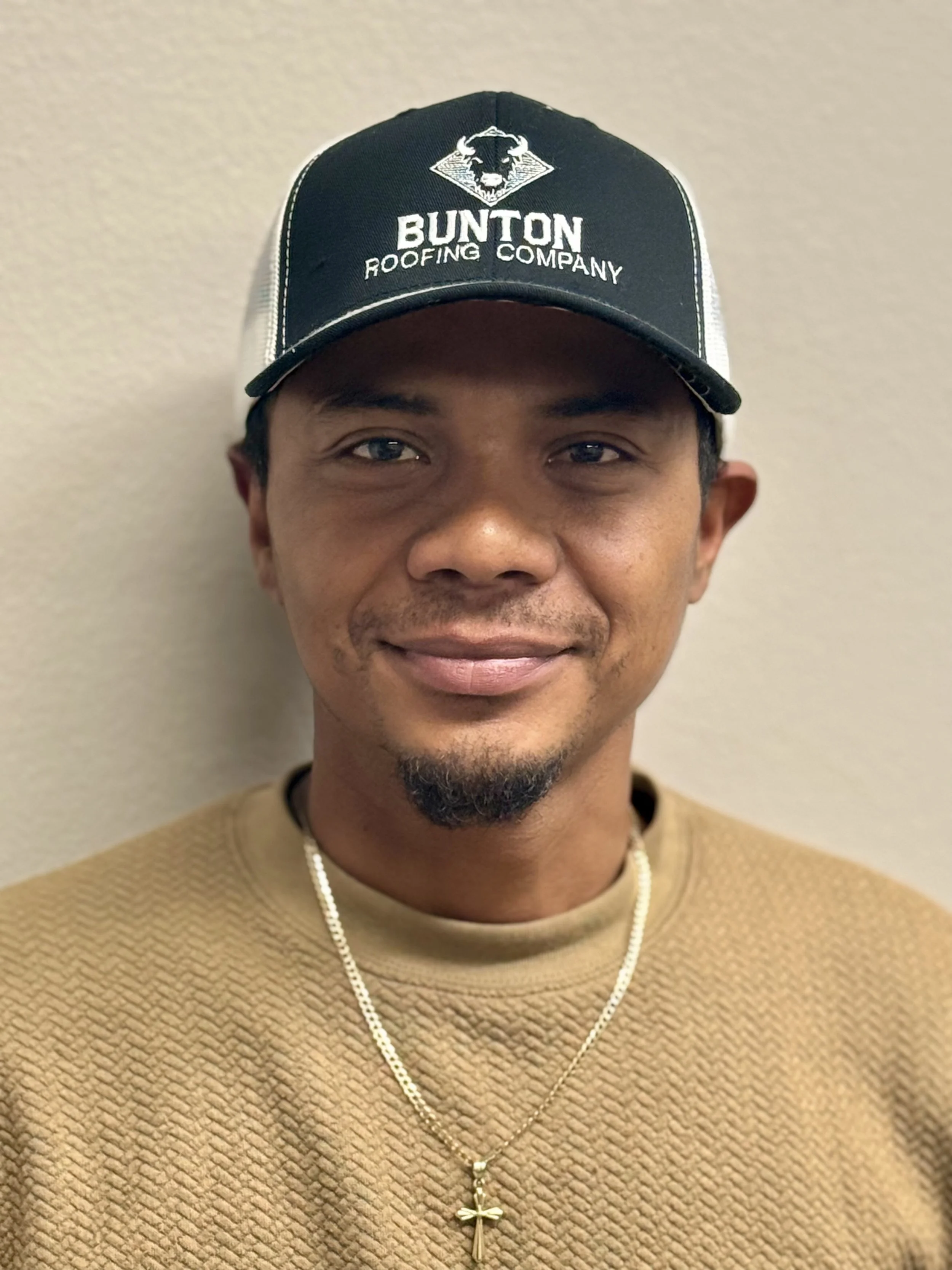 Red pickup truck with logo and contact information parked outside Bunton Roofing Company store.