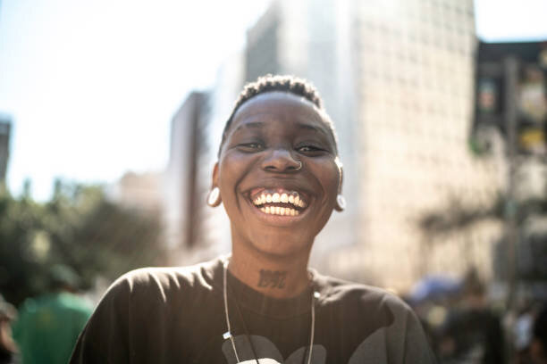 A Black person smiling at the camera.