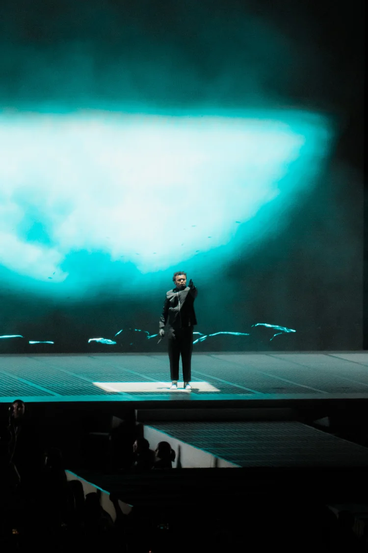 Performer with a blue-green background