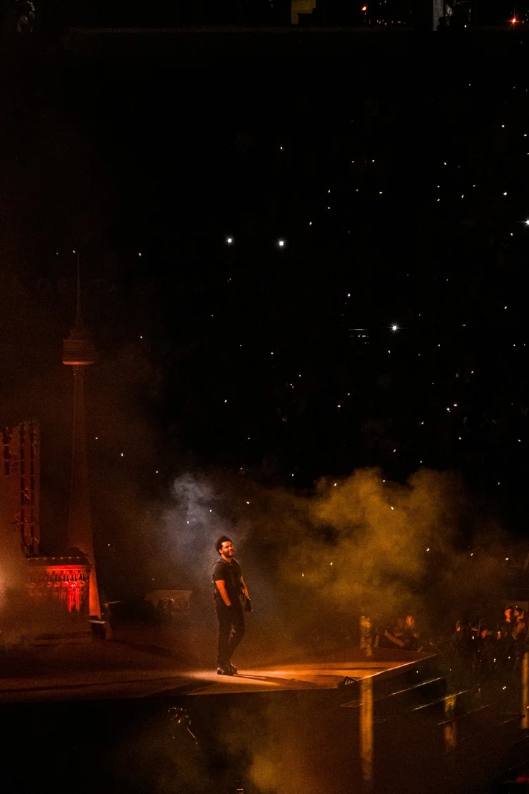 Artist performing with smoke and dramatic lighting