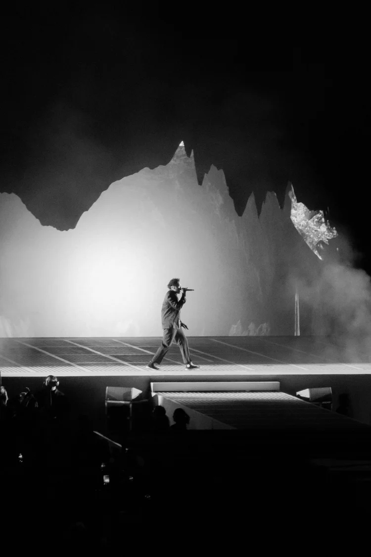 Black and white performer with jagged backdrop
