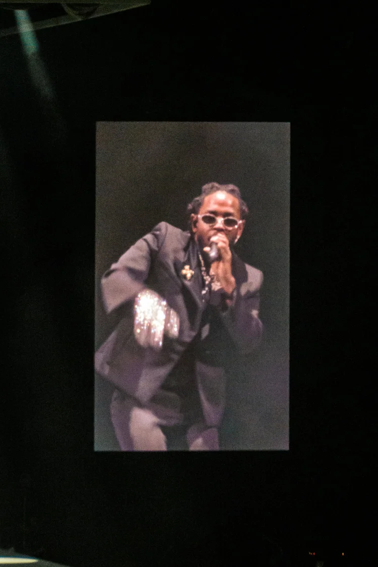 Performer in sunglasses with a large projection