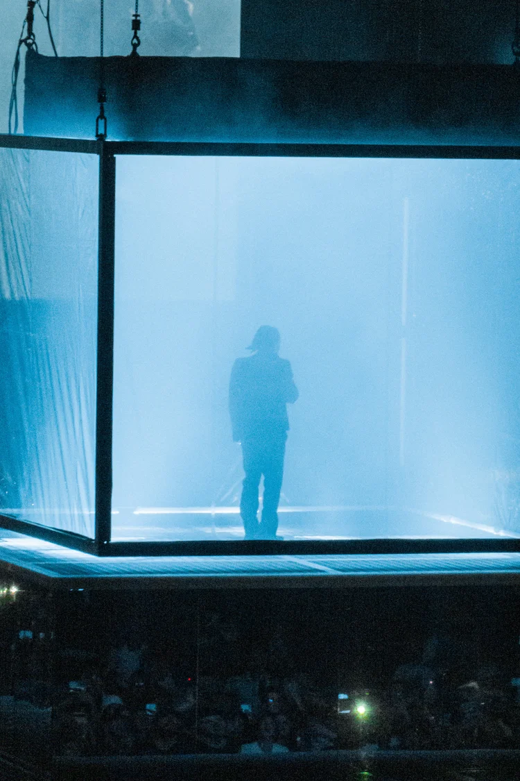 Performer in a blue-lit cube