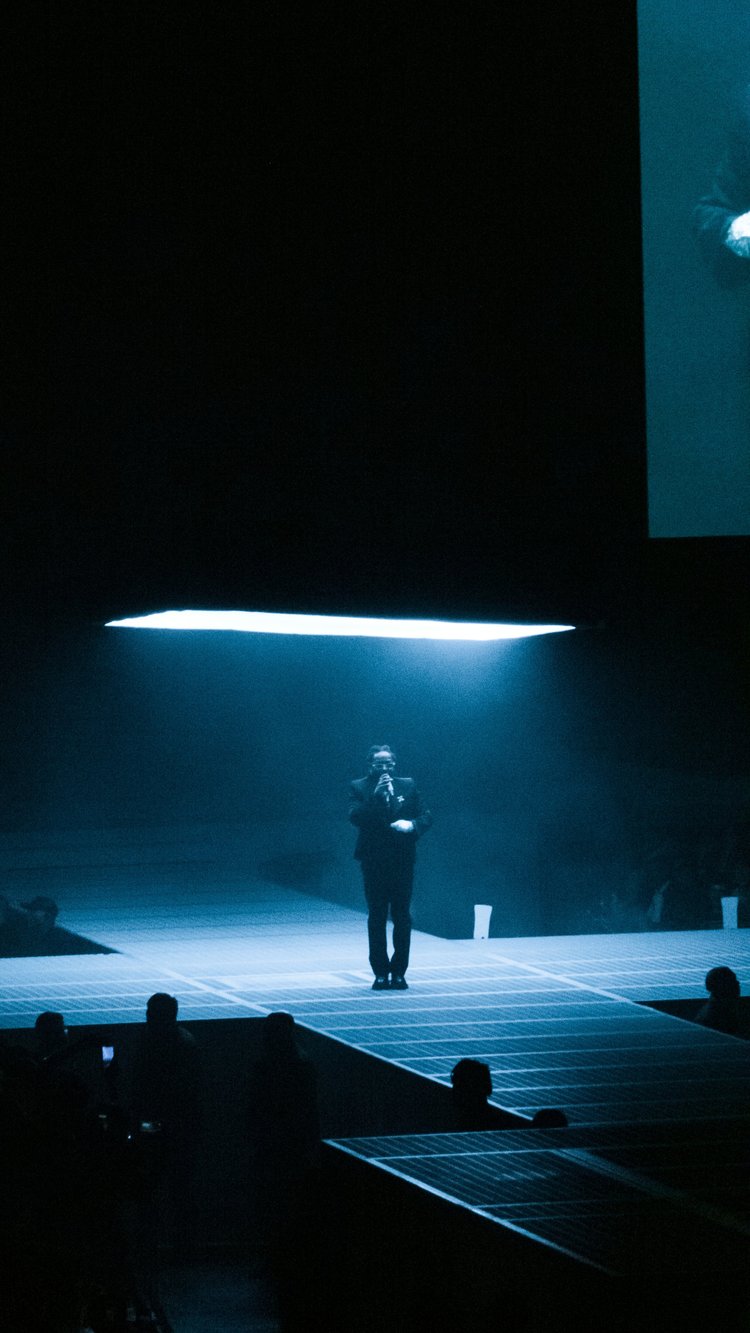 Performer in a suit under a spotlight