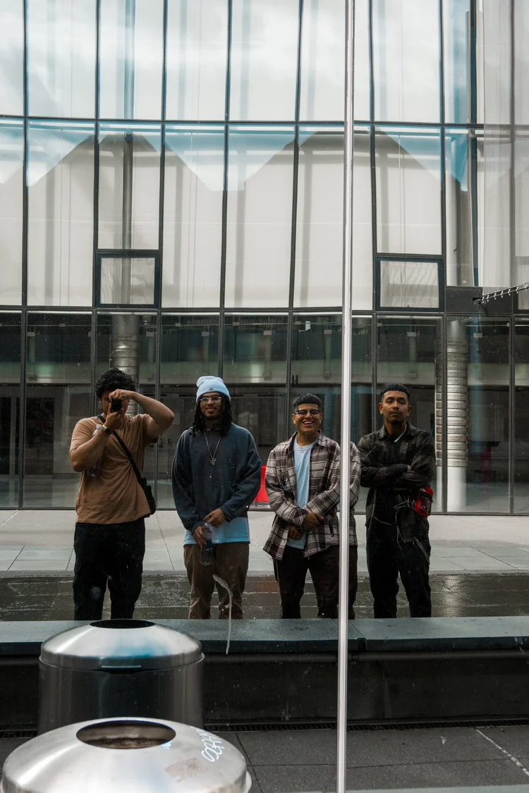 Four men reflected in a glass building